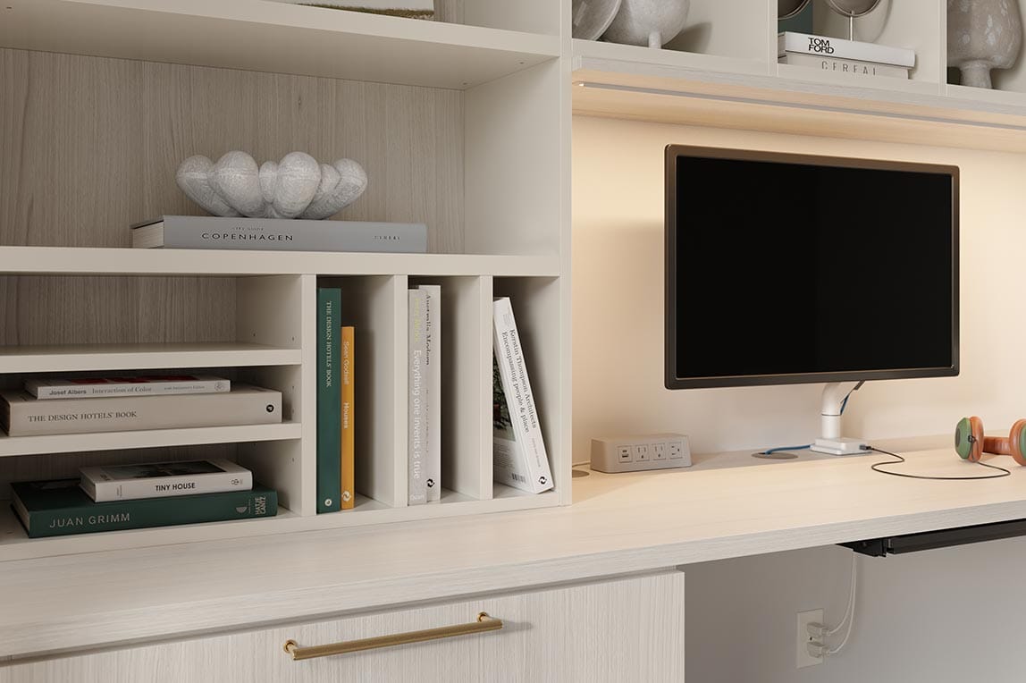 Custom shelf dividers built in to the wall above desk from California Closets